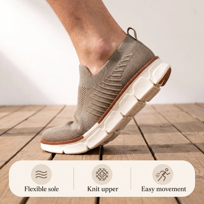 Taupe XE5813 knit slip-on shoe flexing at the forefoot on a wooden floor.