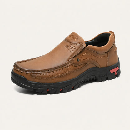 Light brown XK8815 moc-toe slip-on shoe on a warm off-white background.