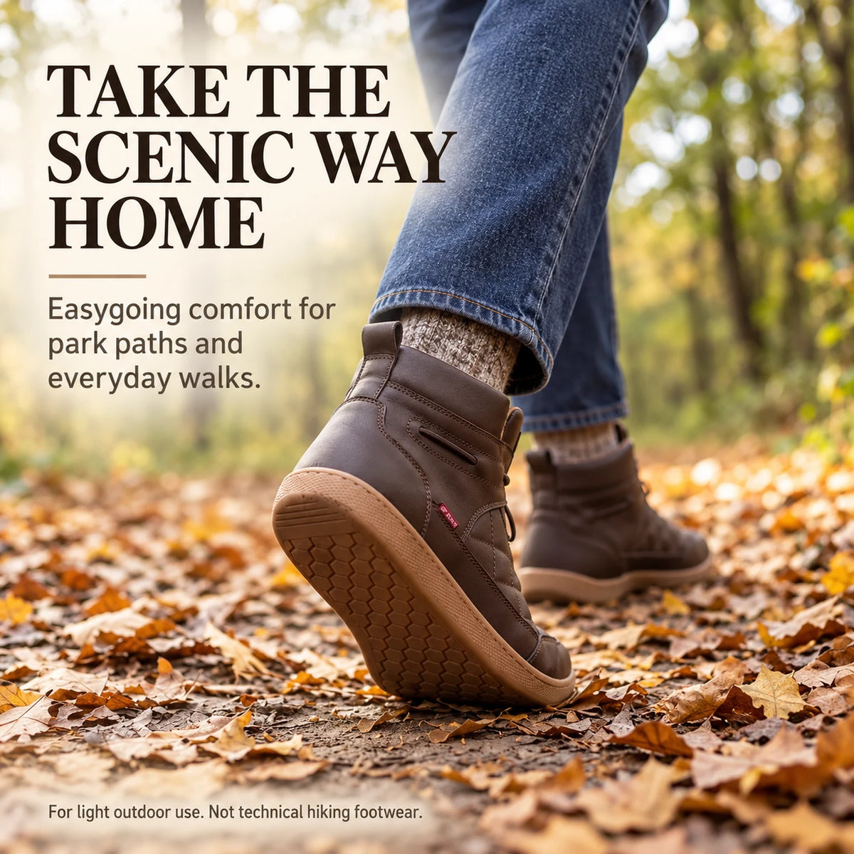 Brown 95856 ankle boots worn with jeans and socks on a leaf-covered autumn park path.