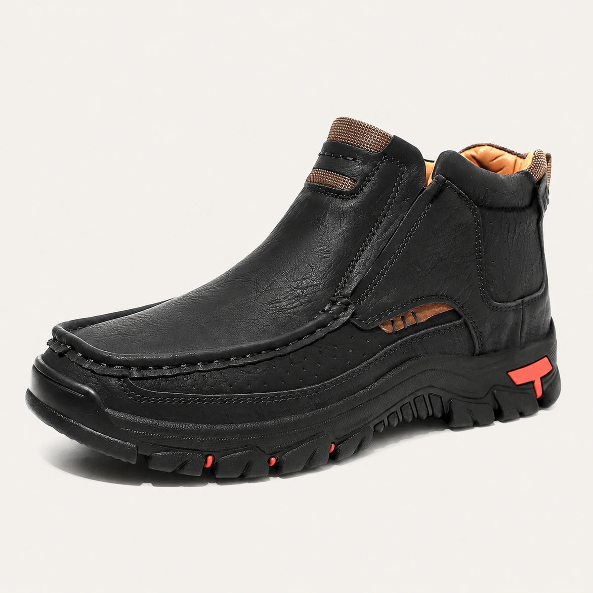 Black 33238 moc-toe slip-on ankle boot with red heel accents on a warm off-white background.